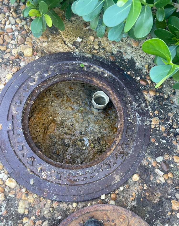 Commercial grease interceptor before cleaning with heavy accumulated grease